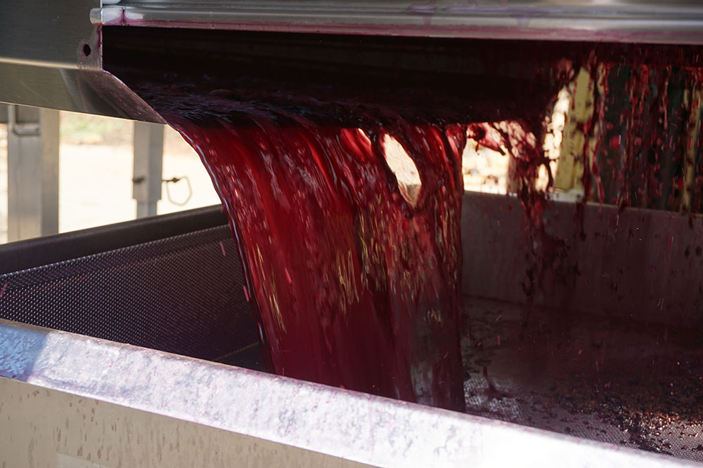 Red wine pouring from machine.